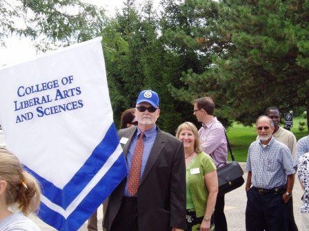 Dean and faculty with the banner